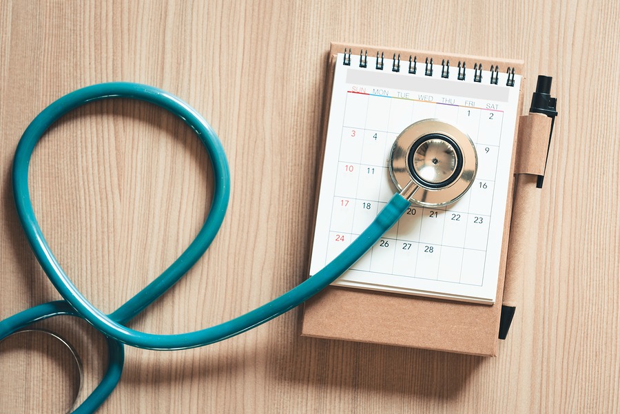 A stethoscope on a notebook opened to a calendar. 
