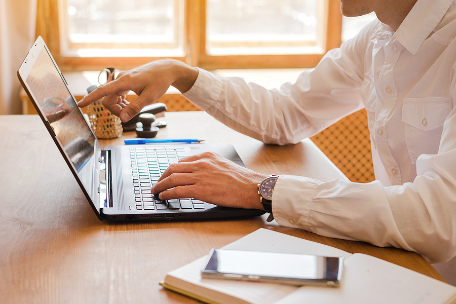 Man using a scheduling software to create hi workplace schedules.