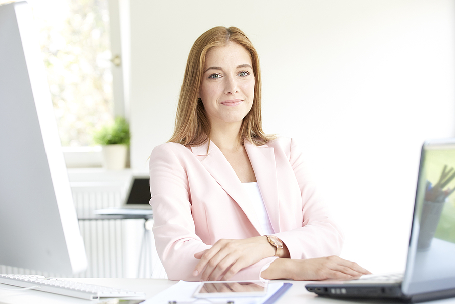 Business woman sitting at her desk in front of a computer.