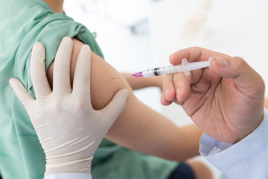 Close up of a pharmacist administering a vaccine. 