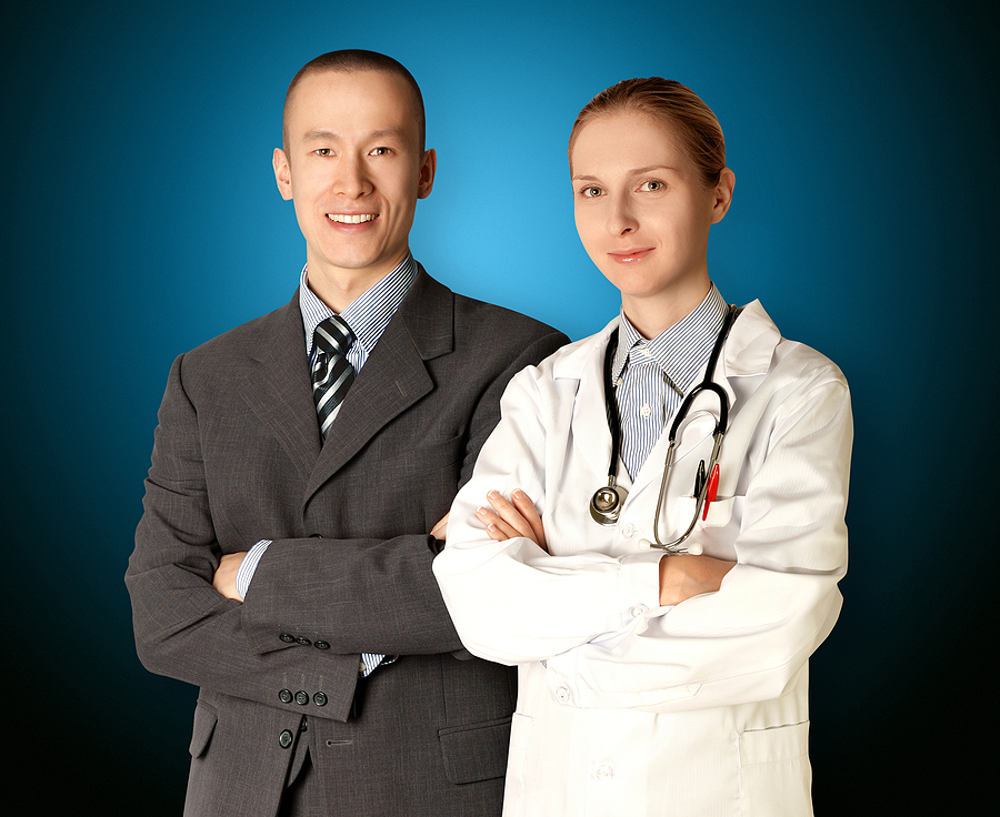 Healthcare admins sranding together with their arms crossed smiling.