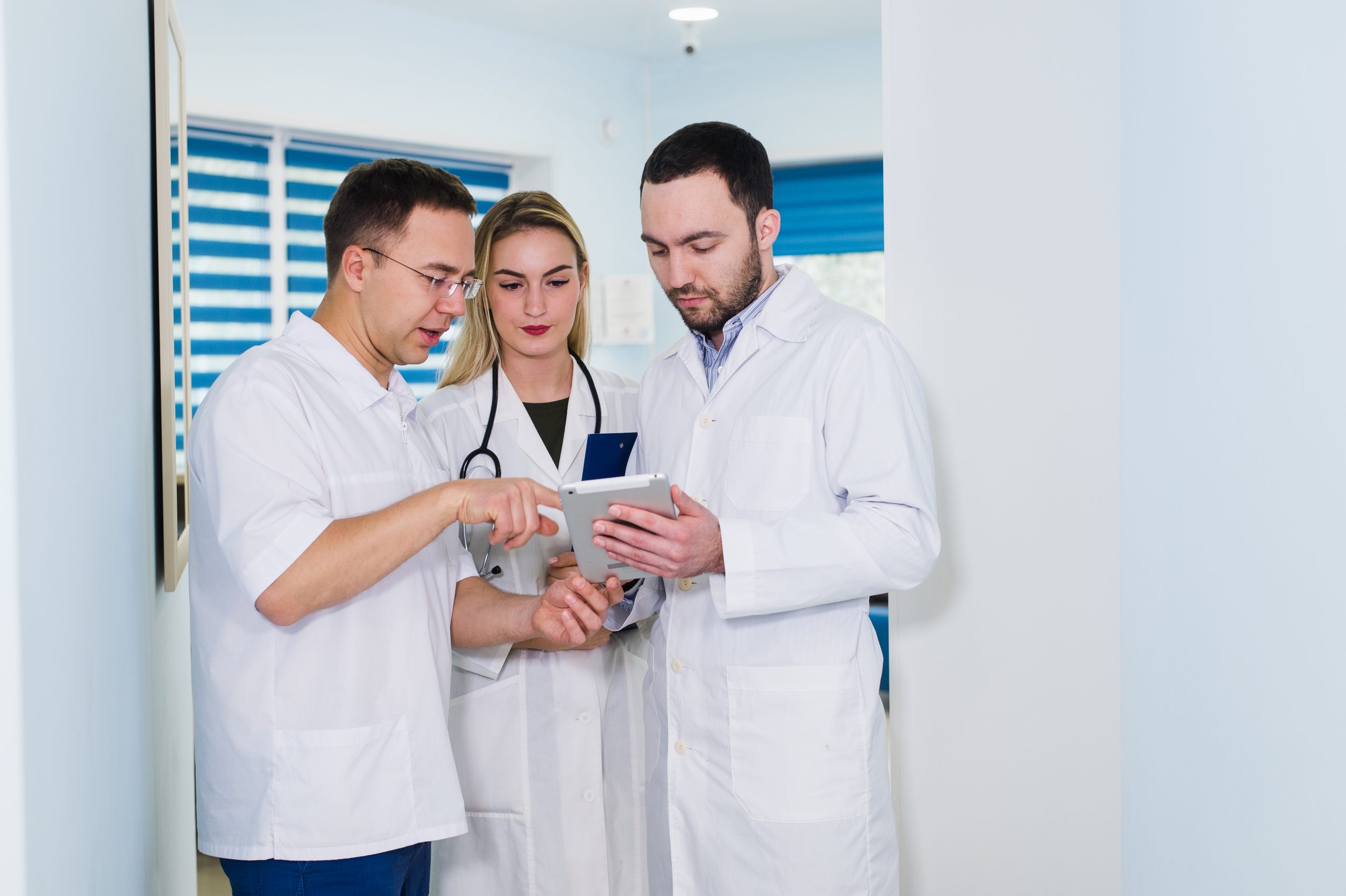 Medical workers looking at a tablet.